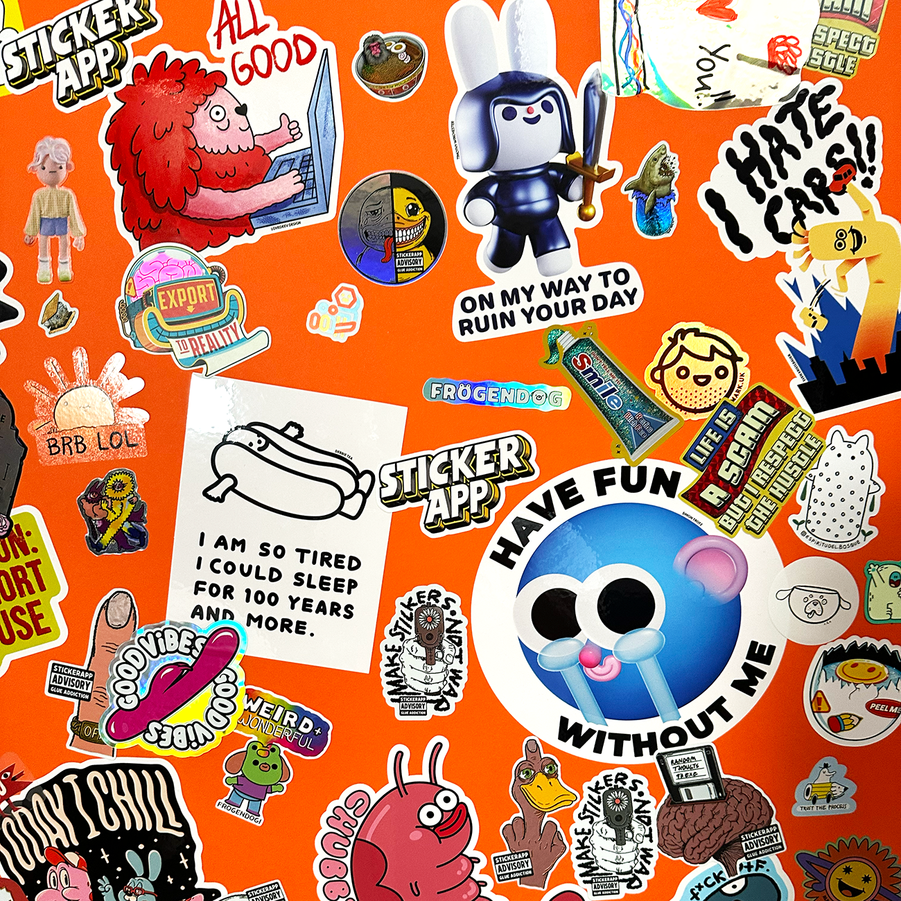 Die-cut stickers printed in various materials and sizes slapped on an orange wall.