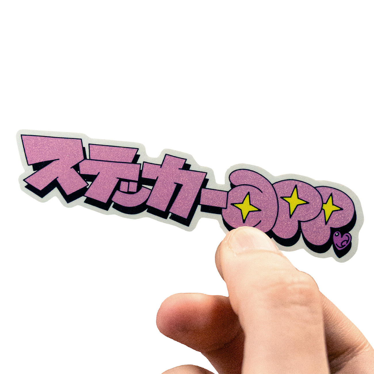 Hand holding a Pixie Dust sticker with Japanese text with 30 percent white layer, against a white background