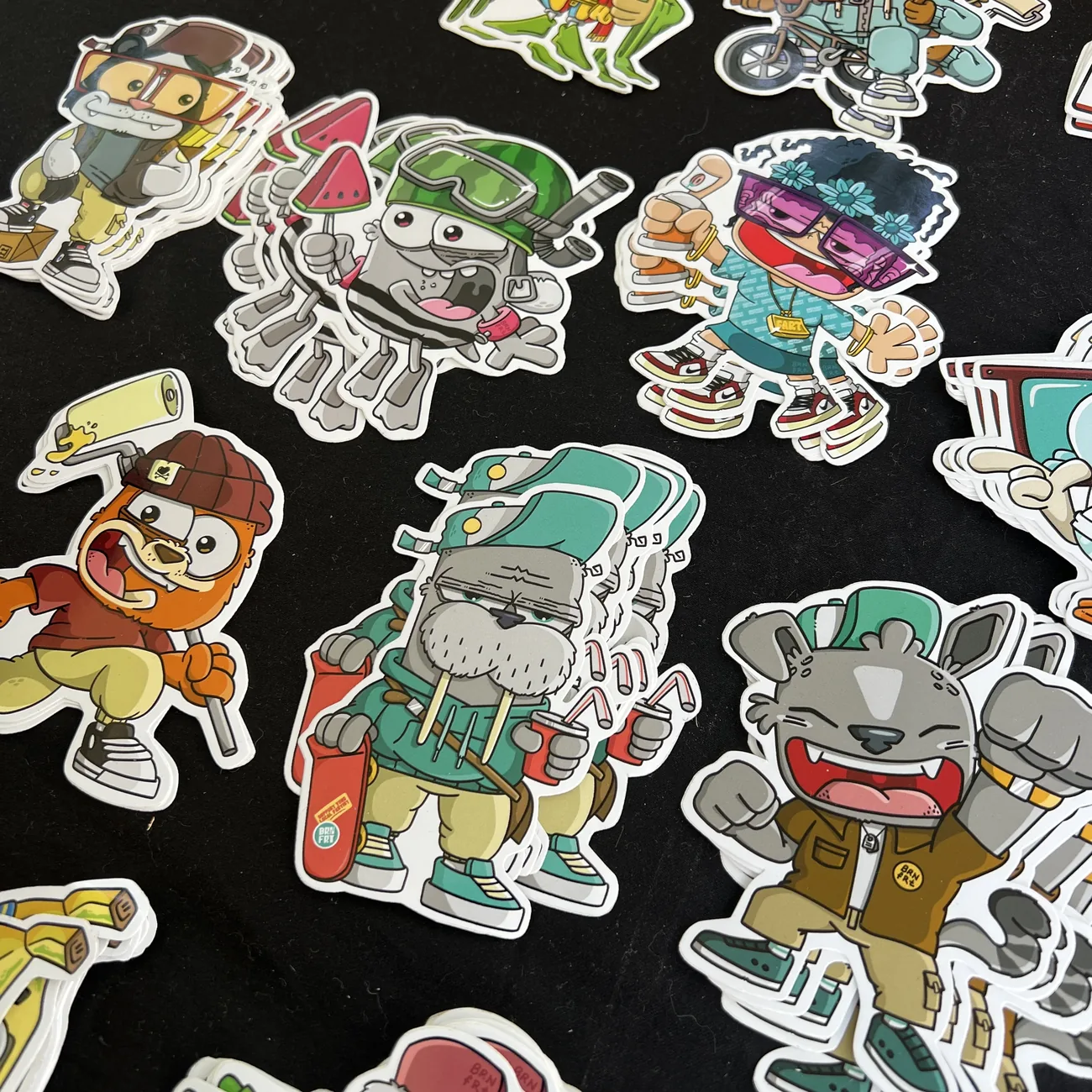 Die-cut klistremerker fra Brainfart x StickerApp med tegnefigurer i streetwear, blant annet en hvalross med skateboard og en glisende katt