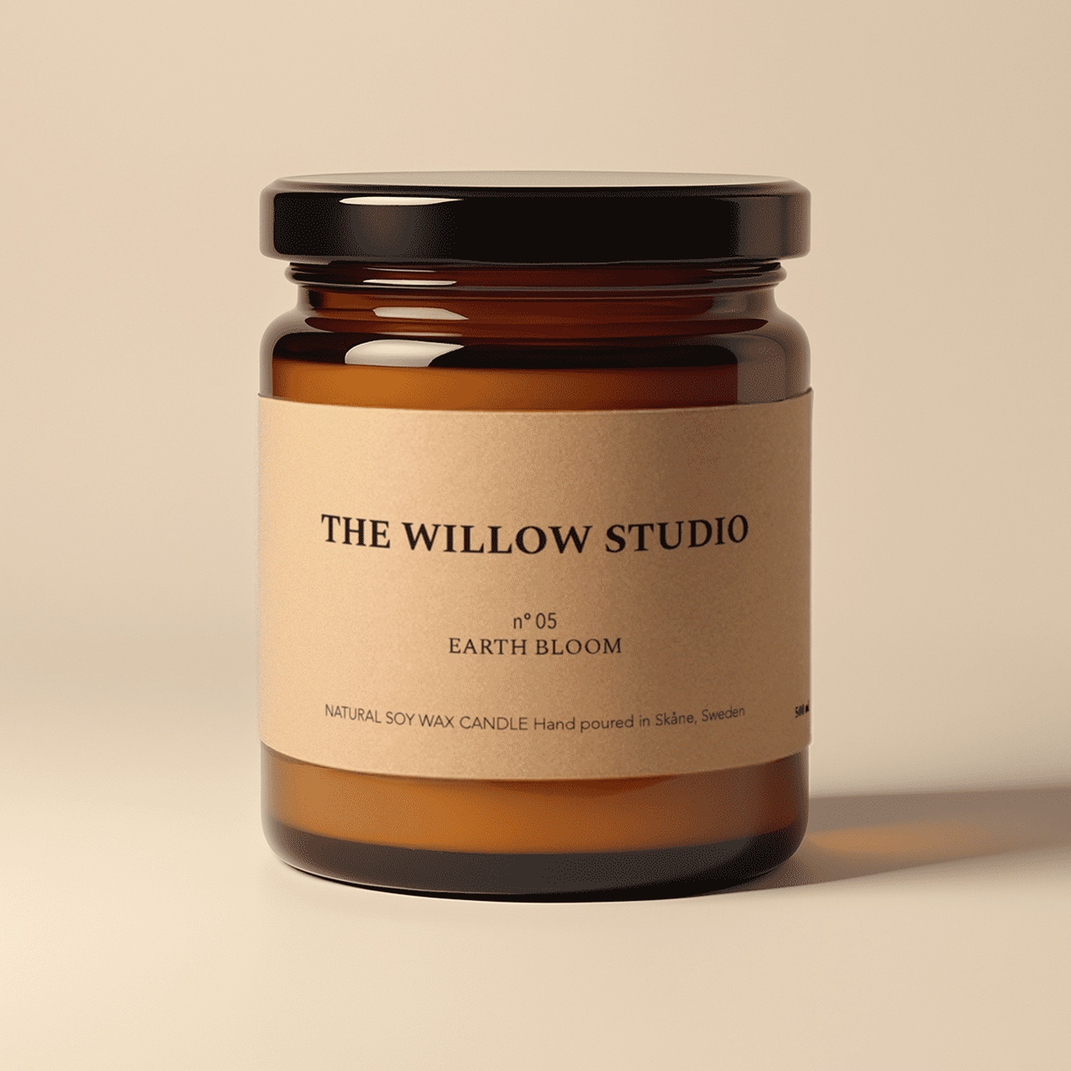Lysglass i ravfarget glass med etikett i kraftpapir for Earth Bloom, et naturlig soyavokslys fra The Willow Studio