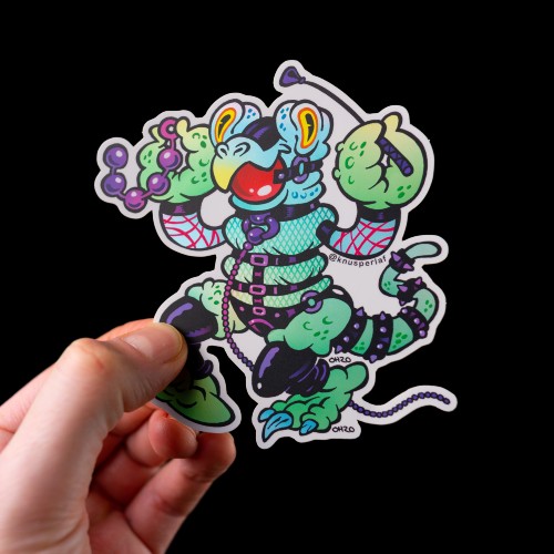 A hand holding a holographic sticker of a kinky cartoon character