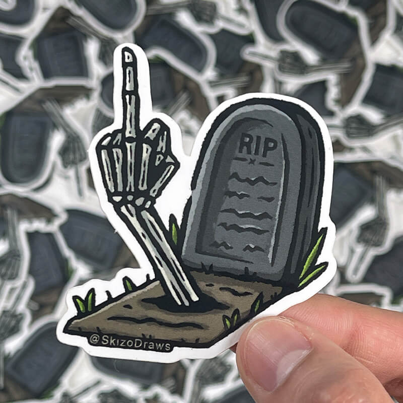 Die-cut klistremerke i vinyl av en gravstein med teksten «RIP» og en skjelettarm som rekker langfingeren opp av bakken, mot en bakgrunn av klistremerker.